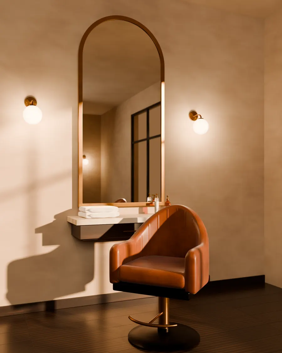 A cognac leather styling chair in front of a tall arched mirror with a brass frame