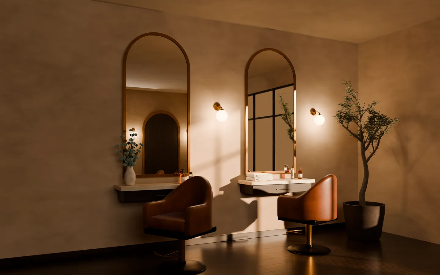 The studio in the evening: two styling stations with tall arched mirrors, cognac leather chairs and brass details against a warm plaster wall